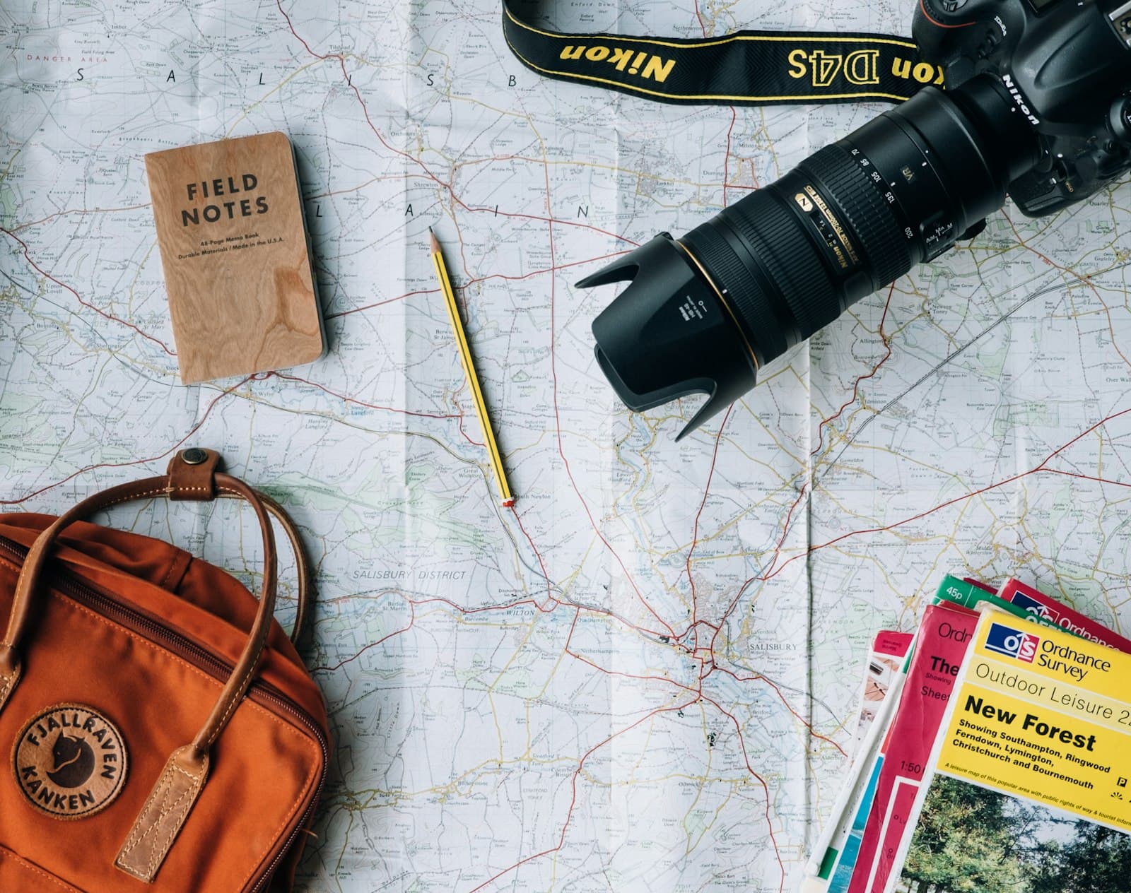 Map, camera and notebook laid out for trip planning